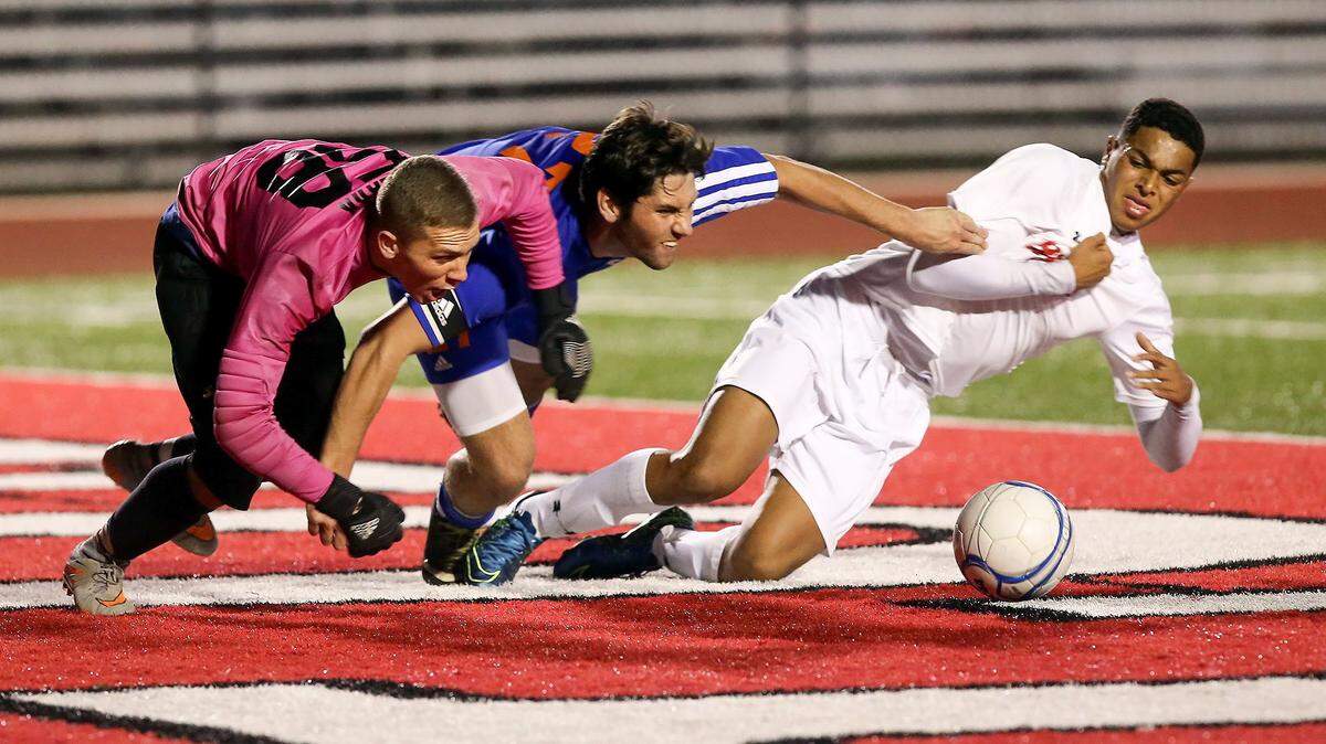 AMANDA McCOY/SUN HERALDGulfport's Alexander Hopkins, center, attempts to break through Biloxi goalkeeper Jacob Clark, left, and Koray Easterling while going for the ball on Tuesday.