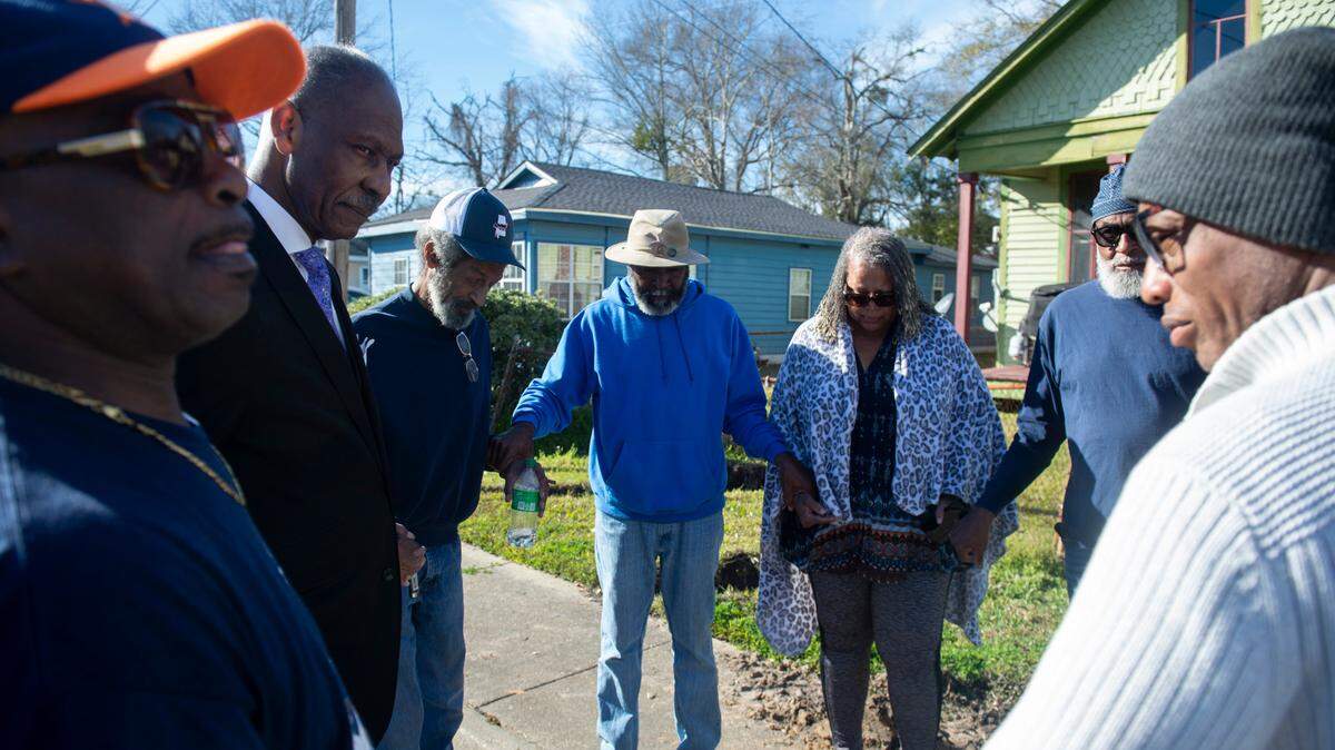 Pastor O’Neil Wiley, second from left, leads family members and friends of Harold Payne and Jittaun Payne in prayer outside the Paynes’ home in Pascagoula on Thursday, March 6, 2025. The Paynes were killed on Wednesday when their son Darold Sim Payne allegedly beat them to death with a cinderblock.