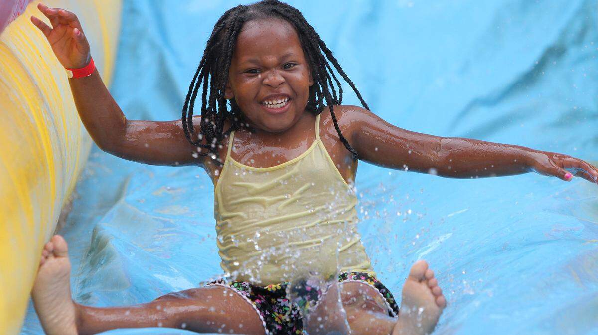 JOHN FITZHUGH/SUN HERALD 
 Saje Williams, 5, of Gulfport, goes down a water slide during Family Fun Day at Hiller Park in Biloxi on Saturday May 28, 2016.