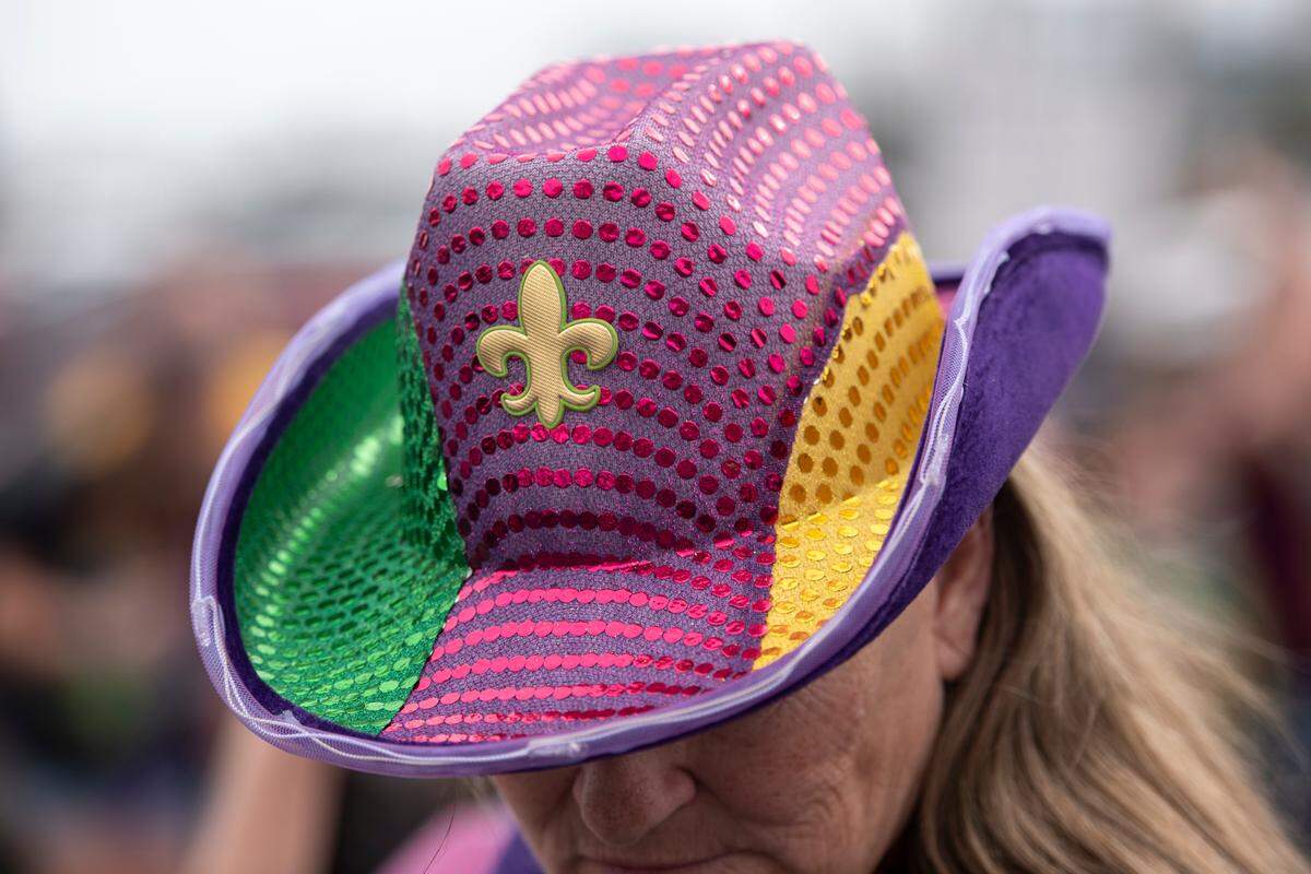 A paradegoer wears a Mardi Gras hat during the Krewe of Gemini parade in downtown Gulfport on Saturday, Feb. 10, 2024.