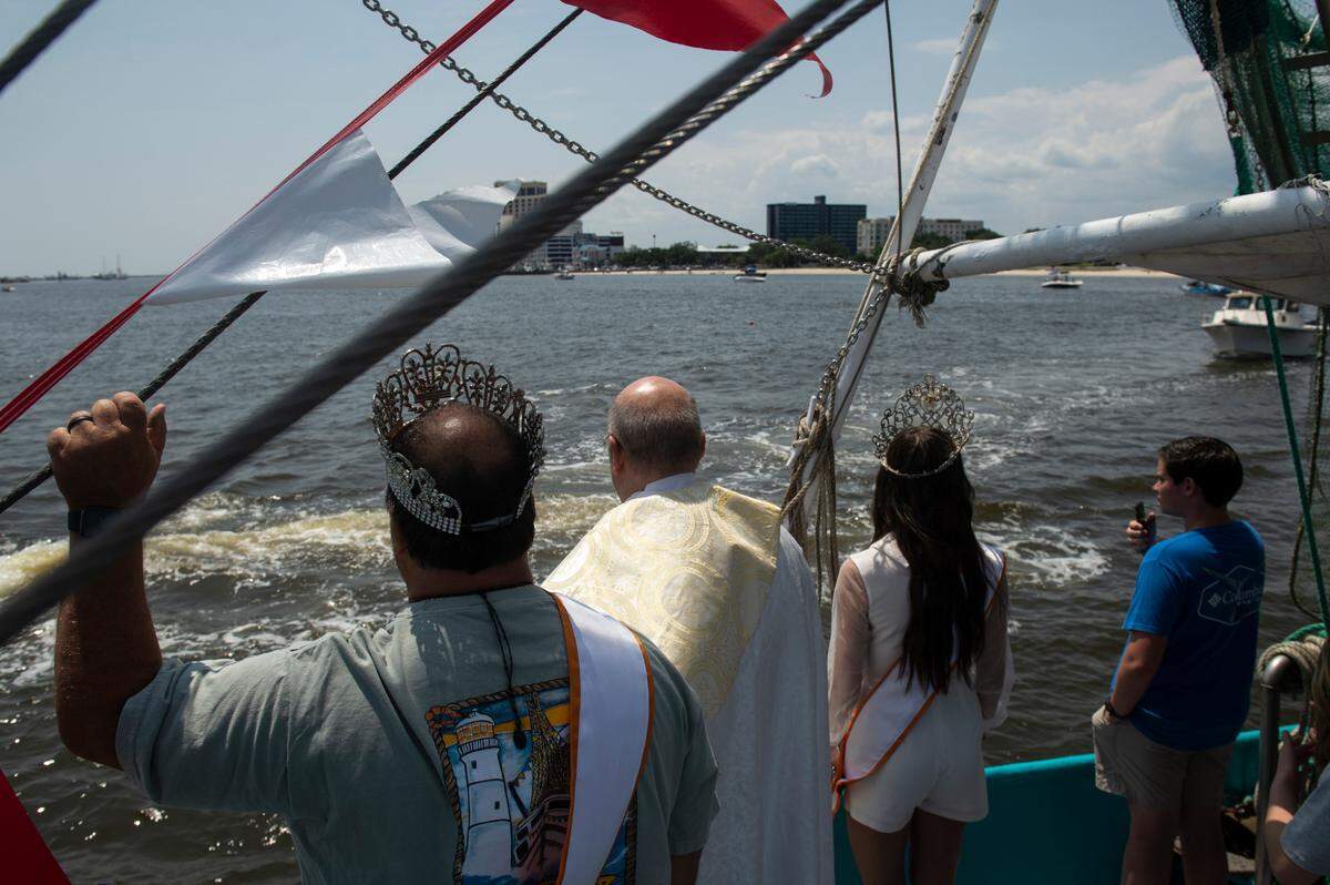 Shrimp King Wally Gollot, Msgr. Dominick Fullam, and Shrimp Queen Elizabeth Wetzel during the Blessing of the Fleet in Biloxi on Sunday, May 28, 2023.
