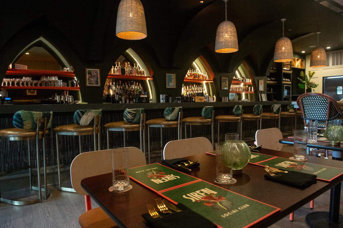 The bar and the seating area at Siren Social Club inside Hotel Vela in Gulfport is moody and a big draw for the community.