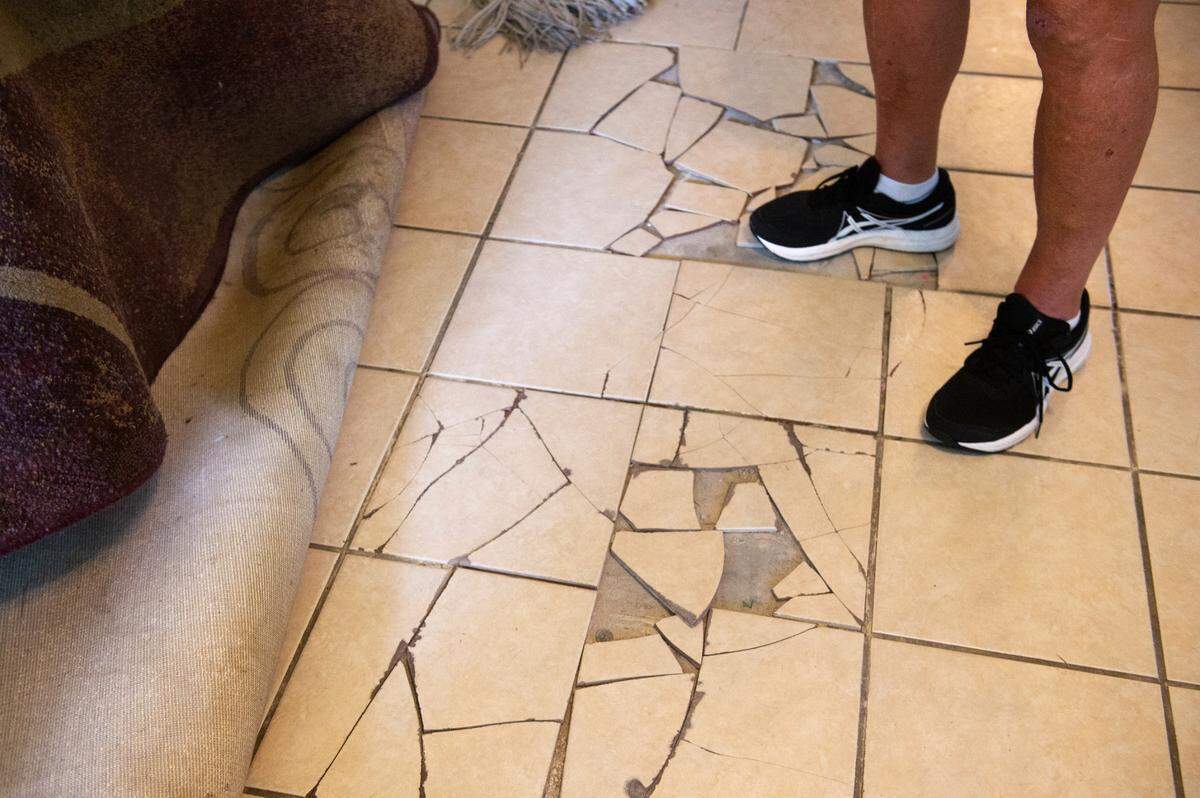Bob Kiesau stands on the cracked flooring in his Ocean Springs home on Monday, Aug. 5, 2024. Kiesau says the floor keeps cracking, along with other problems, because of a ditch built near the home that is causing the land underneath his home to sink.