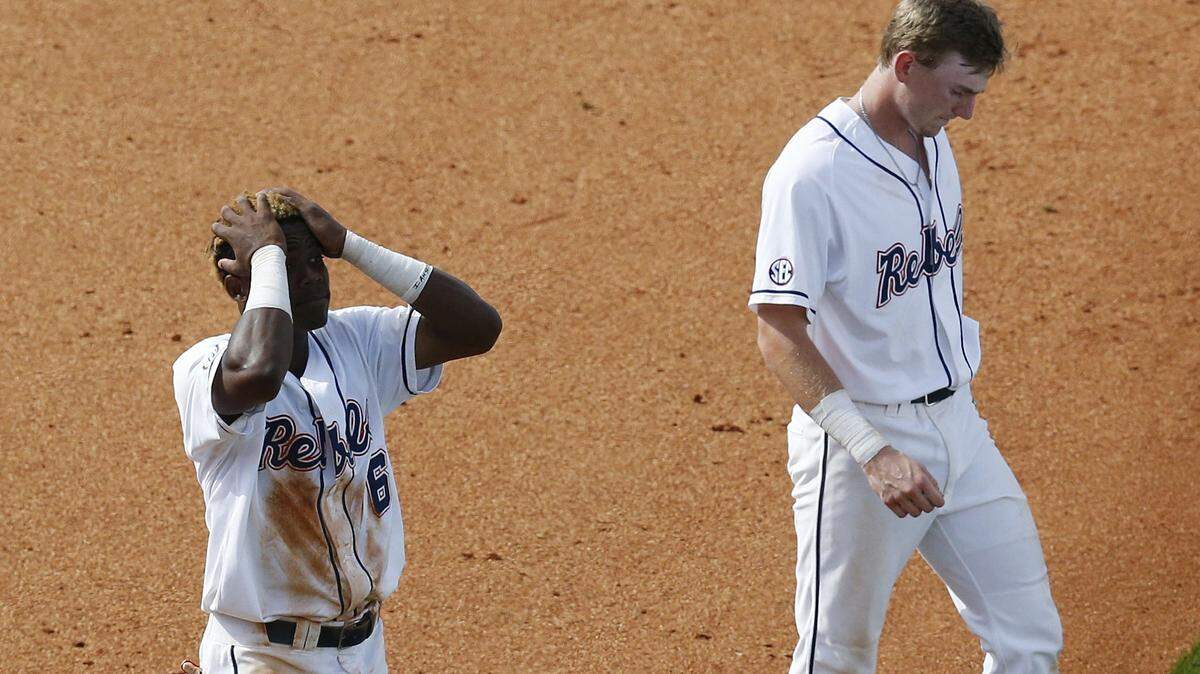 Mississippi's Errol Robinson, left, and Will Golsan, right, walk off the field after losing to Texas A&M in a Southeastern Conference NCAA college baseball tournament game at the Hoover Met, Saturday, May 28, 2016, in Hoover, Ala. (AP Photo/Brynn Anderson)