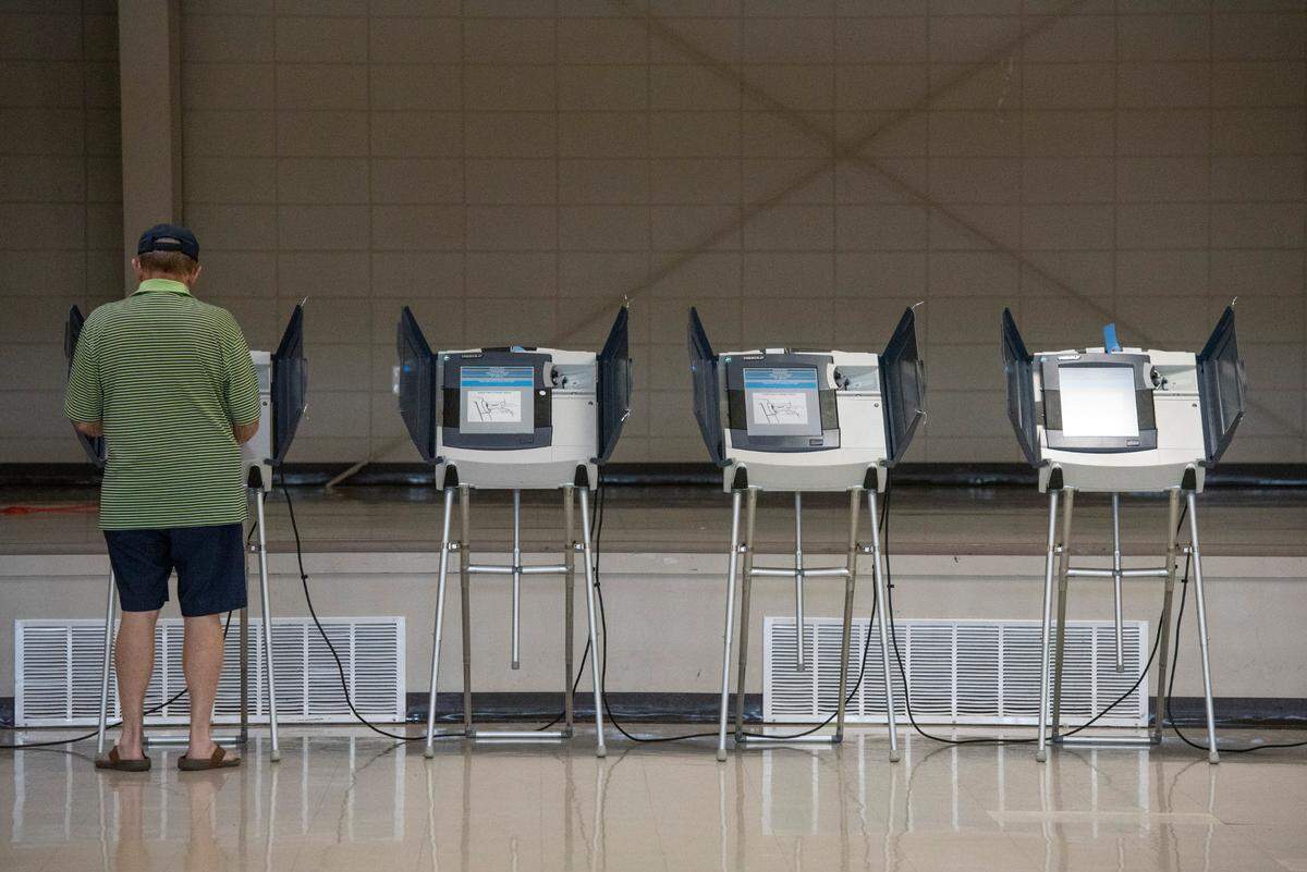 A voter uses an electronic voting machine to vote in the Mississippi primary election at a polling location in Jackson County on Tuesday, June 7, 2022. Individual counties in Mississippi can choose to use electronic or paper ballots.
