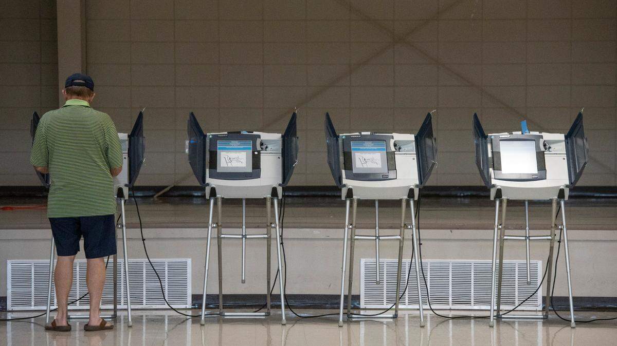 A voter uses an electronic voting machine to vote in the Mississippi primary election at a polling location in Jackson County in 2022.
