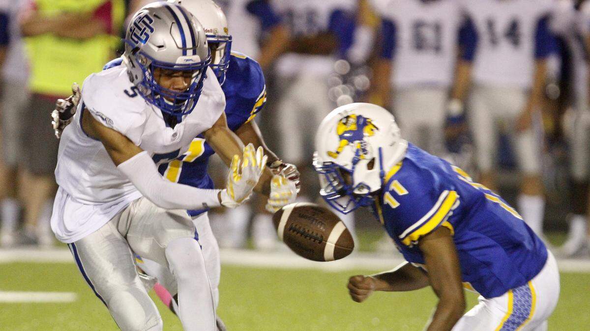 Ocean Springs wide receiver Darien Wallace drops a pass as St. Martin defenders Demarrius Ingram (11) and Elijah Washington close in during the first quarter of their game at Joe Barlow stadium St. Martin on Friday, Oct. 20, 2018.