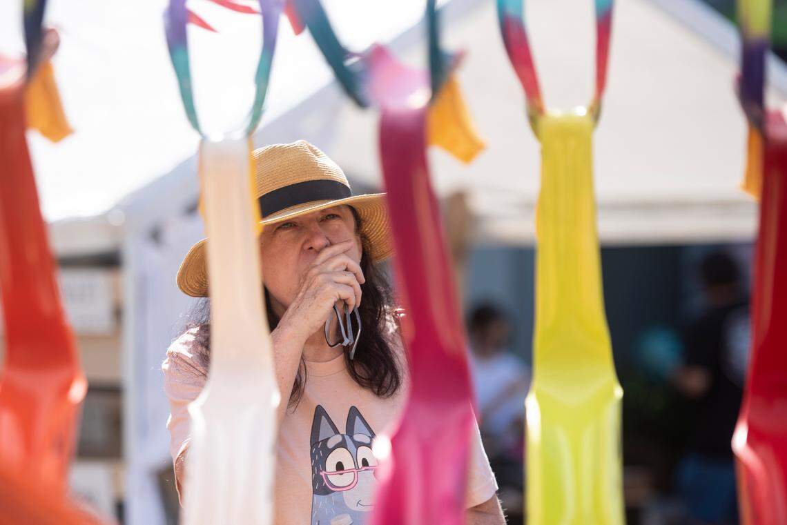A customer admires flamingos made of PVC pipe for sale during the Peter Anderson Festival in Ocean Springs on Sunday, Nov. 6, 2022.