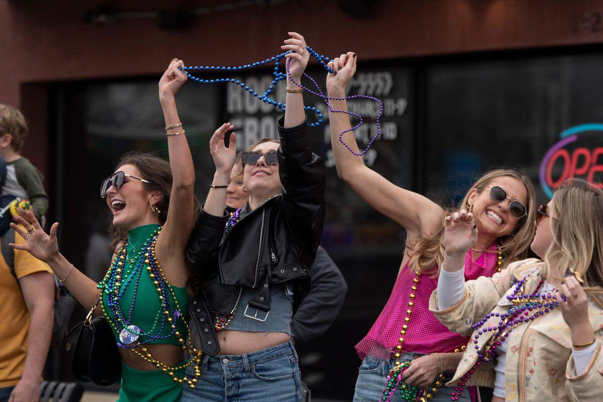 Paradegoers catch beads during the Krewe of Gemini parade in downtown Gulfport on Saturday, Feb. 10, 2024.