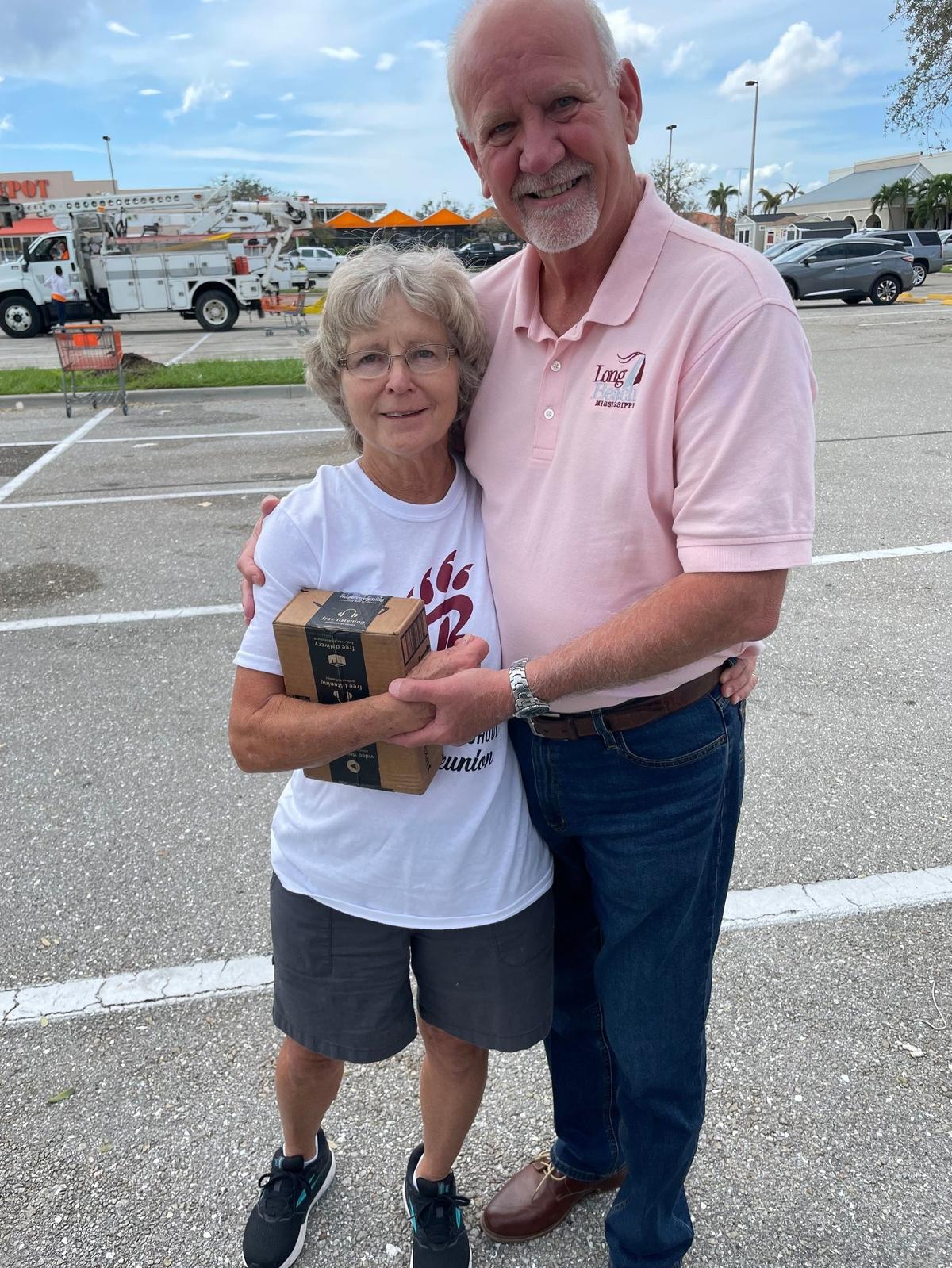 Cindy Eaton stands in Punta Gorda, Fla. with Long Beach Mayor George Bass after Hurricane Ian struck in September 2022. Bass traveled to the city to distribute aid after the Category 5 storm. He also gave Eaton, who is pictured in a Long Beach High School “bearcats” t-shirt, a box of donations from the Class of 1972.