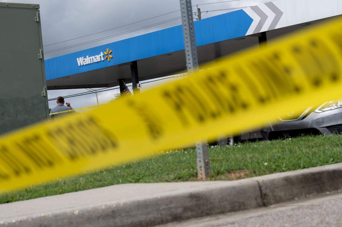 Police tape wraps around the outside of the gas pumps after a shooting at a Gulfport Walmart Neighborhood Market on Tuesday.