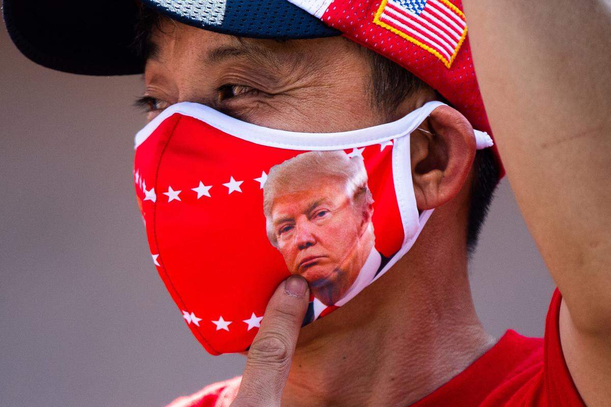 A man at the Cross Country Caravan for Trump rally in Biloxi points to his Donald Trump mask while participating in chants in support of the President on Wednesday, Oct. 7, 2020.