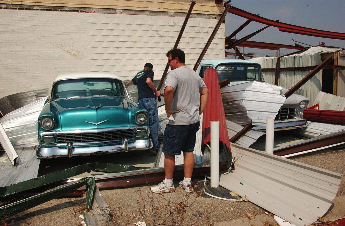 David Ornsby of Gulfport and Chris Montgomery look over a 1956 Chevy Bel Air and 1956 Chevy 3100 pick-up at a storage facility in Gulfport after Hurricane Katrina, Robyn Ornsbey had inhereted the cars from her father. Cruisin the Coast.