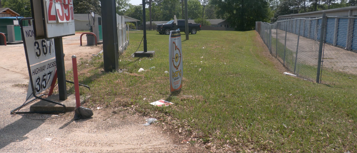 Litter collects in the grass around a gas station in Wiggins. Local officials say major corridors like Highway 49 often see the worst of the problem.
