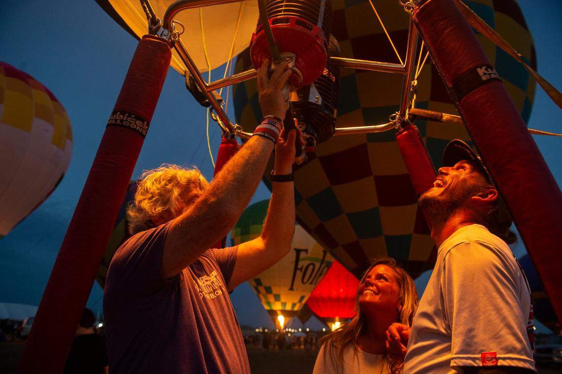 Maui McCraney, right, and Amy Culmoney, of Orange Beach, Alabama, sit inside a hot airballon basket during the Gulf Coast Hot Air Balloon Festival at OWA in Foley, Alabama on Thursday, May 4, 2023.