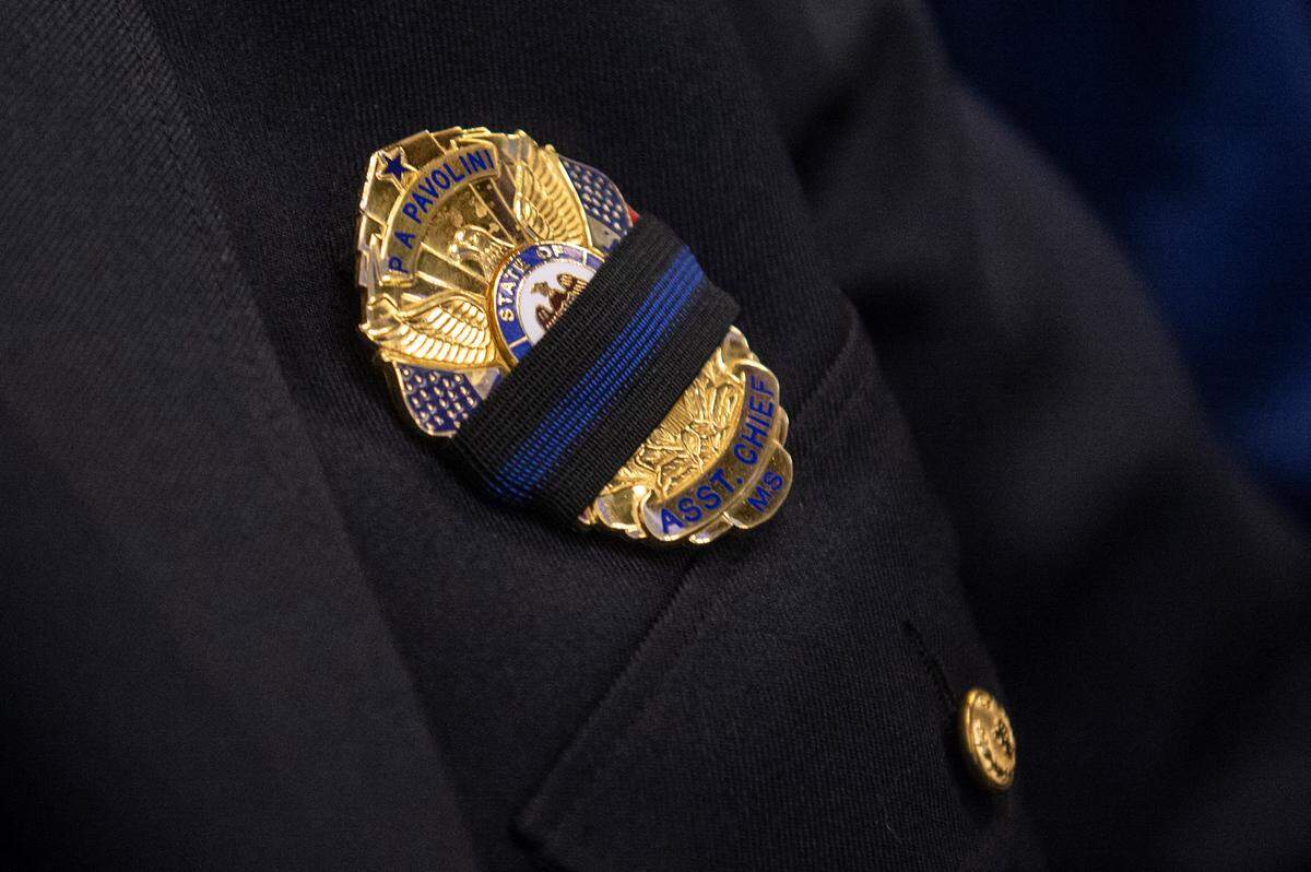 Waveland Assistant Police Chief Philip Pavolini wears a bland band over his badge during the funeral for Bay St. Louis police officers Sgt. Steven Robin and Branden Estorffe at the Bay St. Louis Community Center in Bay St. Louis on Wednesday, Dec. 21, 2022.  