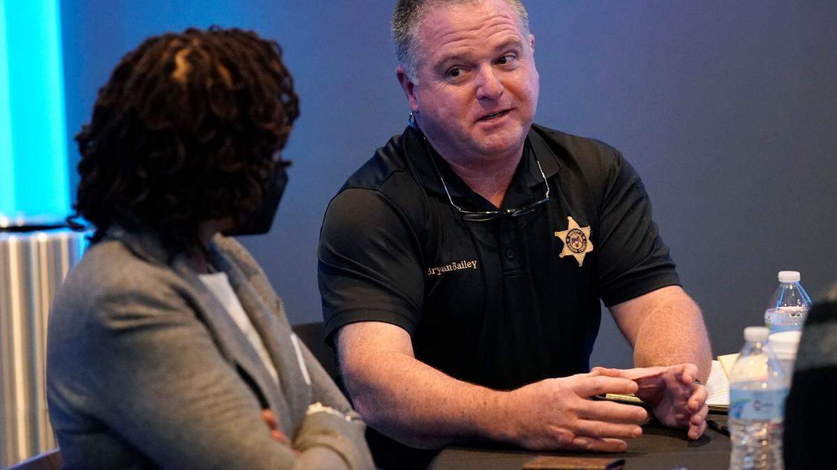 FILE - Rankin County Sheriff Bryan Bailey, right, speaks to an attendee at an employer engagement forum in Jackson, Miss., Nov. 4, 2021. Bailey announced Tuesday, June 27, 2023, that an unspecified number of Rankin County deputies had been fired because of their involvement in a Jan. 24, encounter in which two Black men said six white deputies handcuffed and beat them and one of the Black men was shot in the mouth. (AP Photo/Rogelio V. Solis, File)