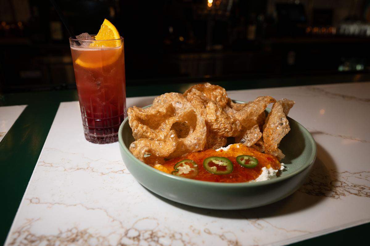The pork rinds and the walk of shame cocktail are served during a soft opening for Neighbors Tap & Table on Thursday.
