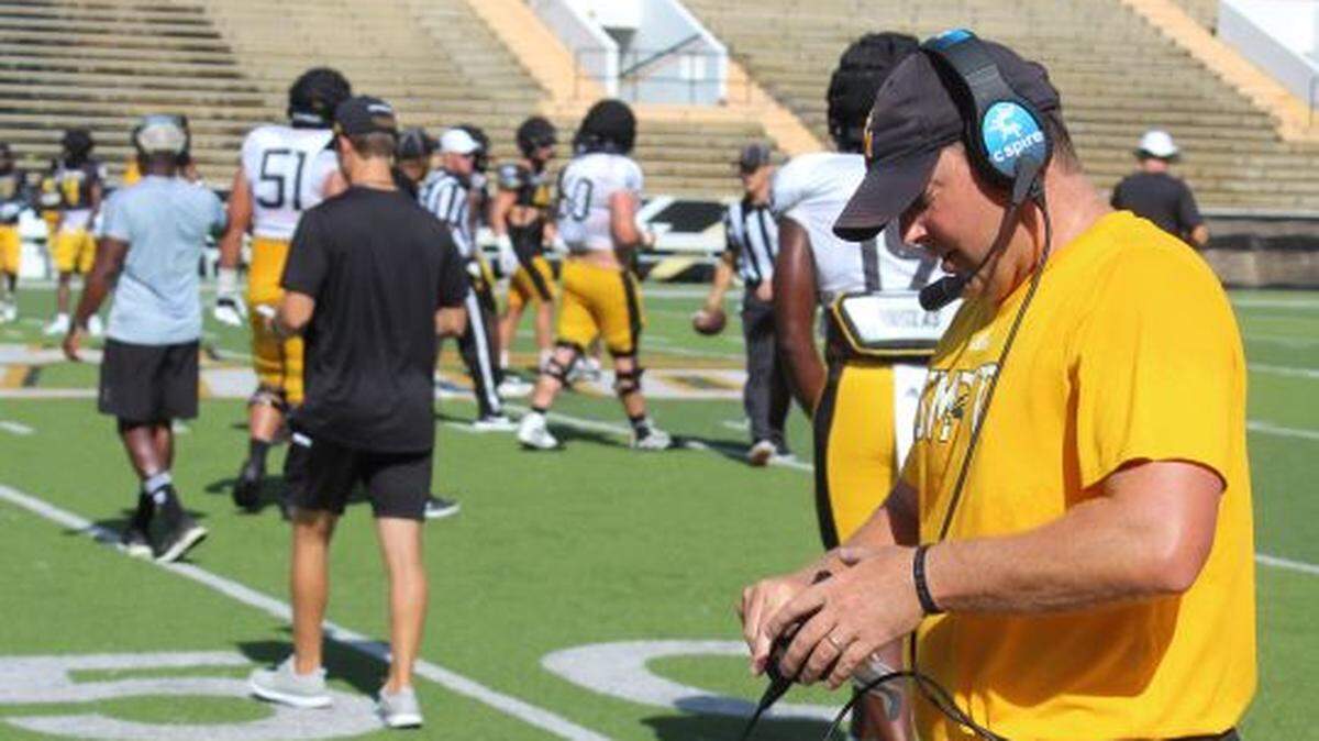 Head football coach Will Hall adjusts his mic pack during the final preseason scrimmage with the Southern Miss team on Saturday, Aug. 21, 2021.
