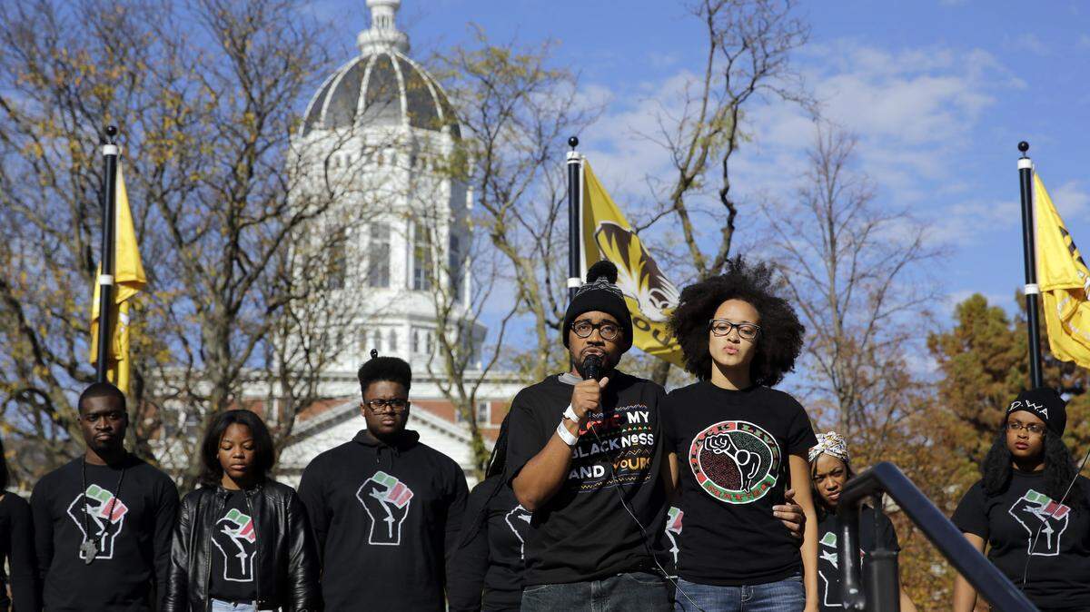 In this Monday, Nov. 9, 2015 file photo, Jonathan Butler, front left, addresses a crowd following the announcement that University of Missouri System President Tim Wolfe would resign, at the university in Columbia, Mo. Officials were slow to handle racial incidents at the University of Missouri, and that contributed to protests, a student hunger strike, a threatened boycott by the football team and ultimately, the resignations of two administrators. (AP Photo/Jeff Roberson, File)