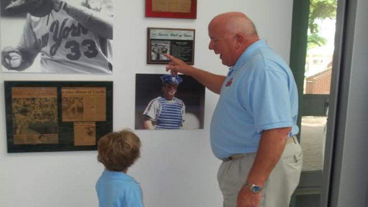 VETO ROLEY/SPECIAL TO THE SUN HERALD 
 Biloxi native and former New York Mets catch Barry Lyons shows grandson Jaxon Kitsos around his exhibit at the Ohr-O'Keefe Museum of Art.