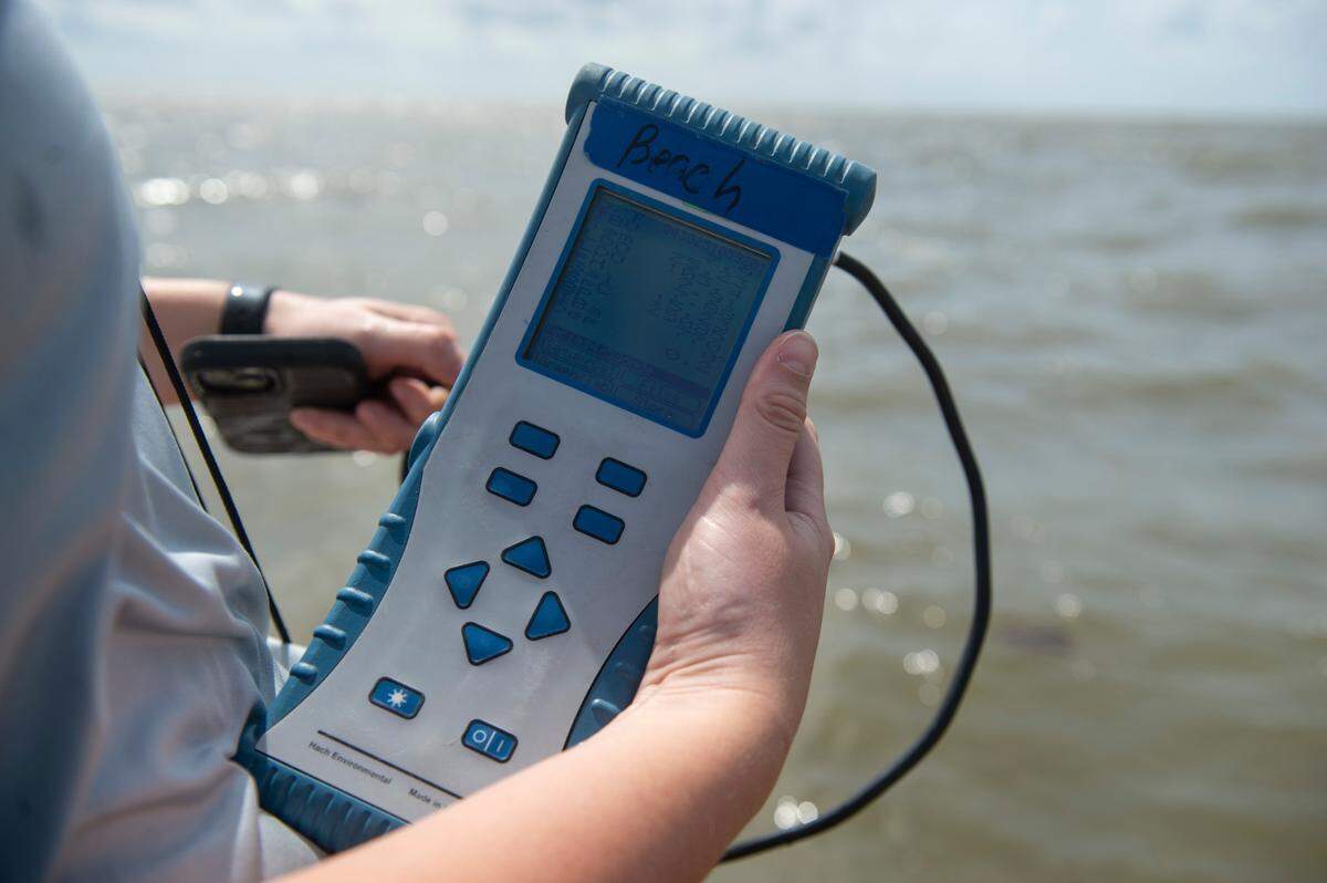 An environmental natural resource specialist with Mississippi Department of Environmental Quality uses a hydrolab to collect data at a beach in South Mississippi in this 2025 file photo. MDEQ regularly tests the water quality and issues advisories when bacteria are found.