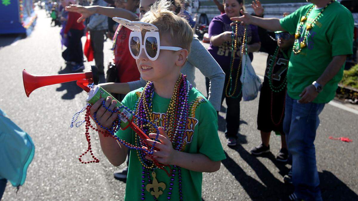 AMANDA McCOY/SUN HERALDGavin Buck, 8, center, enjoys the 26th annual Orange Grove Carnival Association Mardi Gras parade Jan. 16 in Gulfport.