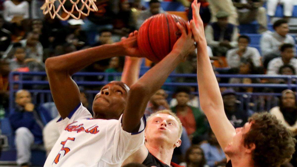 AMANDA McCOY/SUN HERALD 
 Gulfport's Dequarius McCord, left, grabs the rebound from Metamora's Jordan Dehm, right, and Noah Persich, center, as the buzzer sounds to end the first quarter of the championship game of the Gulfport Hardwood Holiday Classic on Wednesday, December 30, 2015.