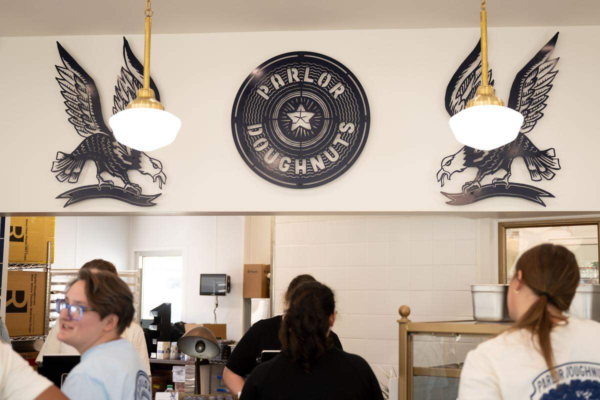 Employees gather at the front counter of Parlor Doughnuts for training on Thursday, October 16, 2025.