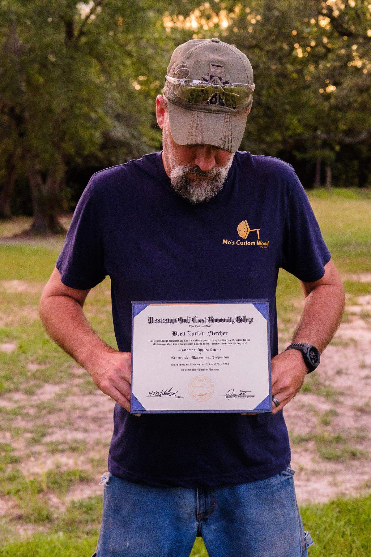 Brett holds his diploma from MGCCC.