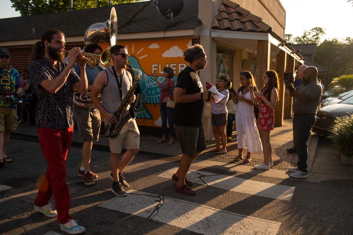 Blackwater Brass, a jazz band, leads the second-line funeral for Carl the rooster down Government Street in Ocean Springs on Tuesday, May 10, 2022.