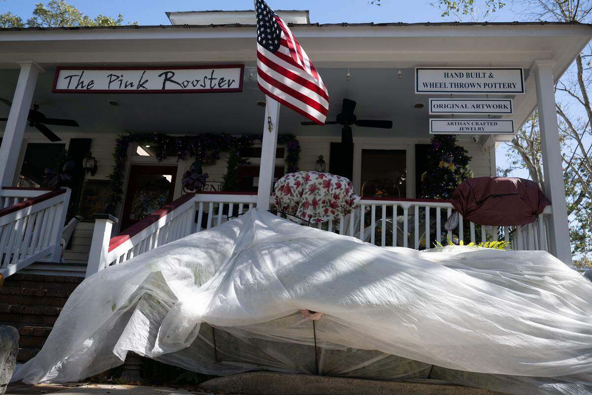 A covering is placed Monday over plants outside The Pink Rooster to protect from winter weather.