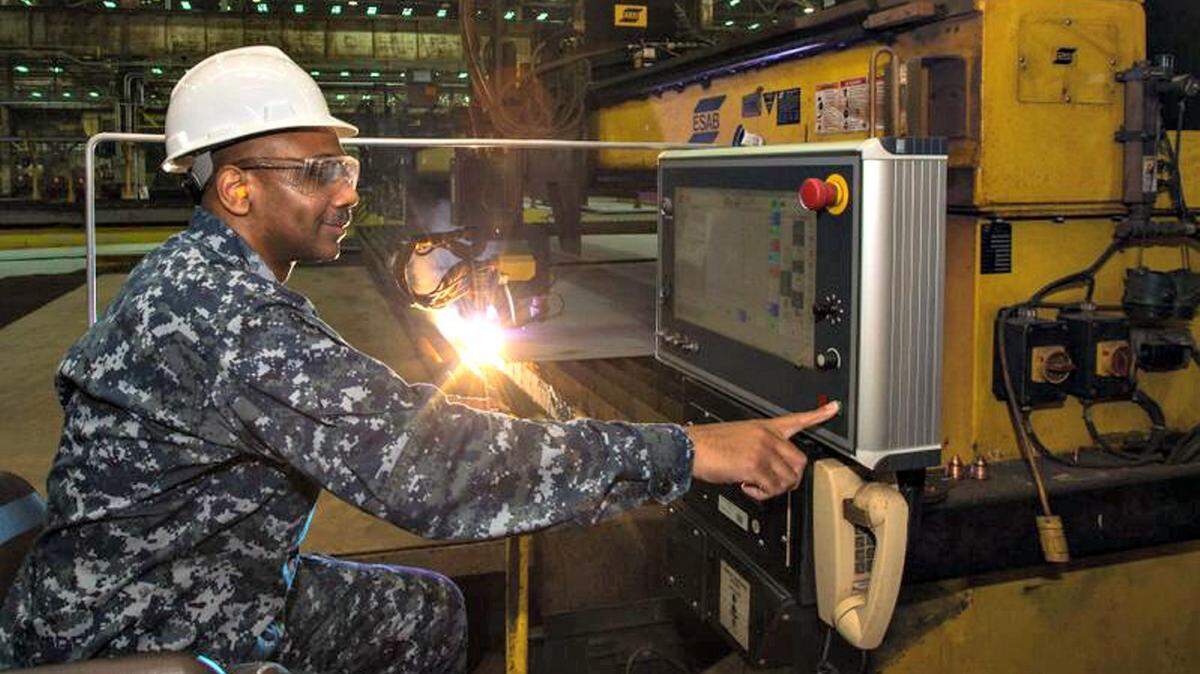 LANCE DAVIS/HUNTINGTON INGALLSCmdr. Dave Murray, post-delivery officer for the U.S. Navy's DDG 51 program, presses the button to start fabrication of the Ingalls-built destroyer Frank E. Petersen Jr. (DDG 121).