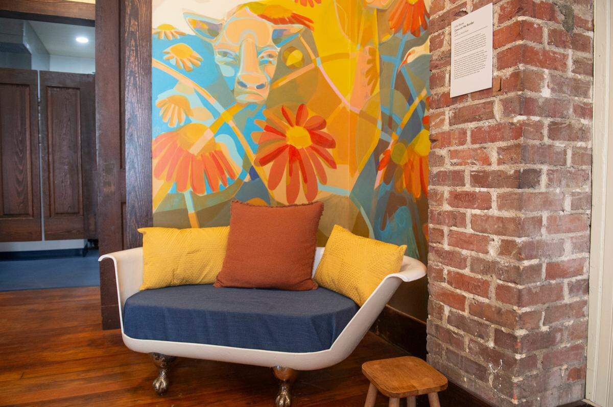 A chair made from a bathtub sits in front of a mural by Julia Reyes at The Traveler, a new extension to the Walter Anderson Museum of Art, in Ocean Springs on Wednesday, April 16, 2025.