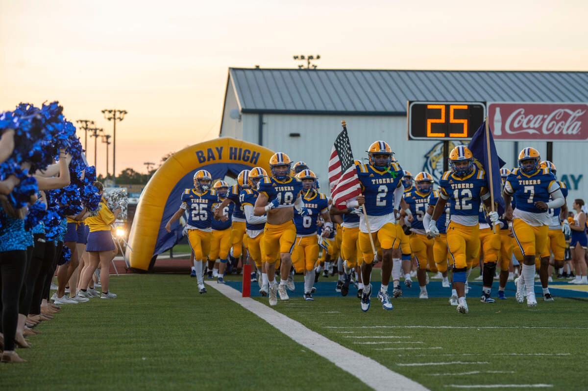 The Bay High Tigers football team runs out before a game between Bay High and Long Beach at Tiger Stadium in Bay St. Louis on Friday, Sept. 13, 2024.