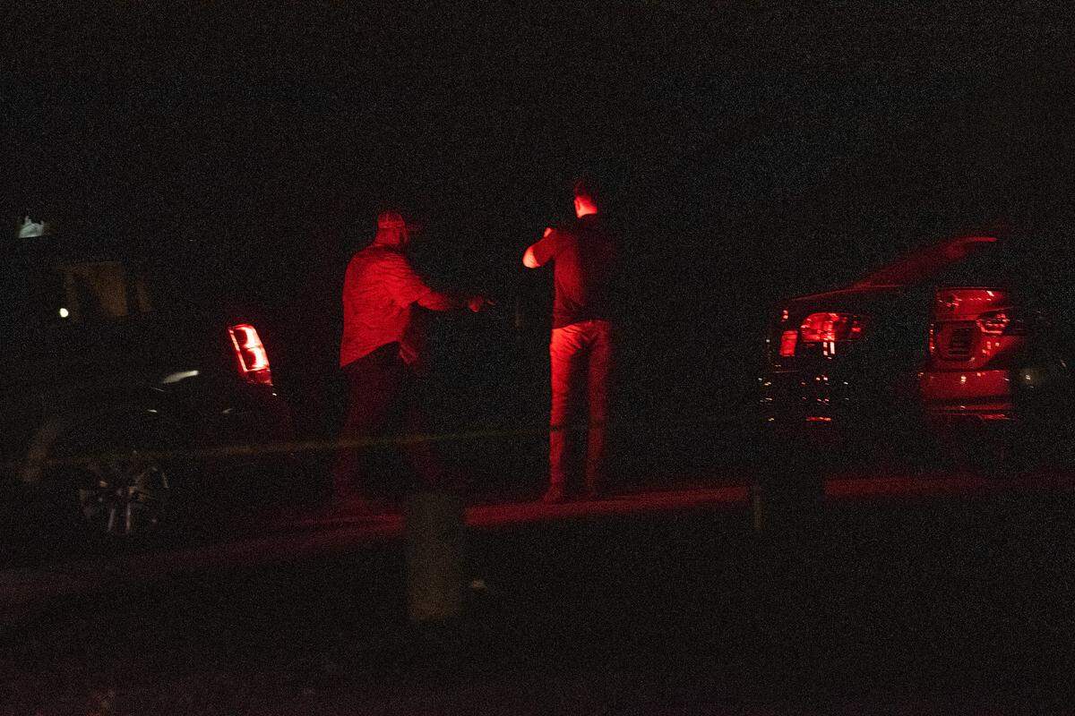 Police officers stand outside a home on Oakview Circle in Latimer after four people were killed inside on Thursday, April 7, 2022.
