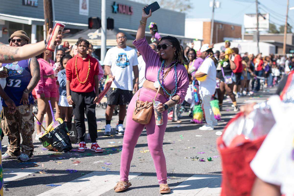 Parade attendees dance during the Jackson County Carnival Association Mardi Gras parade in Pascagoula on Saturday, March 1, 2025.