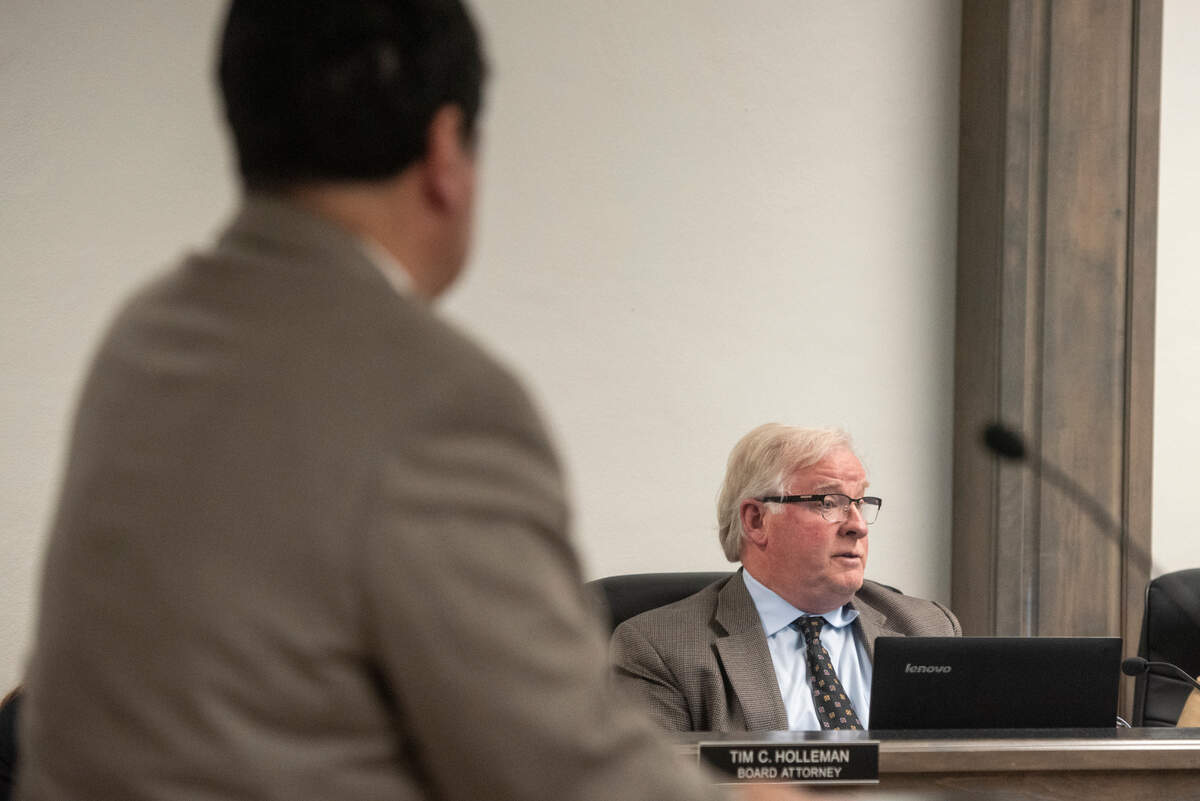 Biloxi city attorney Peter Abide stands before the Harrison County Board of Supervisors as Tim Holleman, attorney for the board, talks with the board about passing a motion requesting the state legislature get local input on a bill that would allow the secretary of state to control leases on the waterfront, during a board meeting in Biloxi on Monday, March 11, 2024.