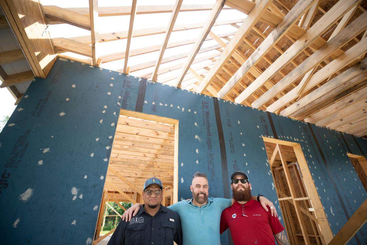 Mike Toribio, left, owner of New Horizon Roofing & Exteriors, along with estimator Samuel White, right, are building a roof that can withstand winds of more than 200 mph for Josh Morgerman, center, who is building a house in Old Town Bay St. Louis. Morgerman is a well-known storm chaser who goes by iCyclone online.