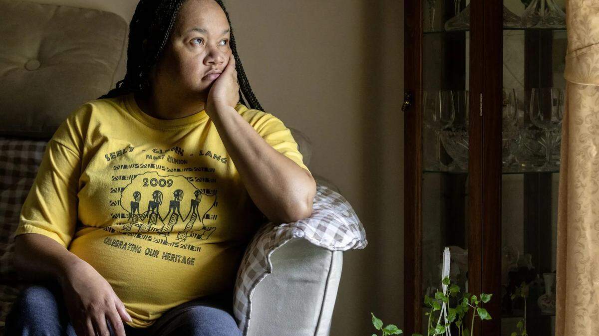 Selinda Walker, 47, looks out of the window at her mother’s house in Columbus, Miss., on Thursday, April 18, 2024. Unable to access necessary care, including tests, treatment, and potentially surgery to manage her Graves’ disease, she was forced to quit working, leading to her return to live with her elderly mother.