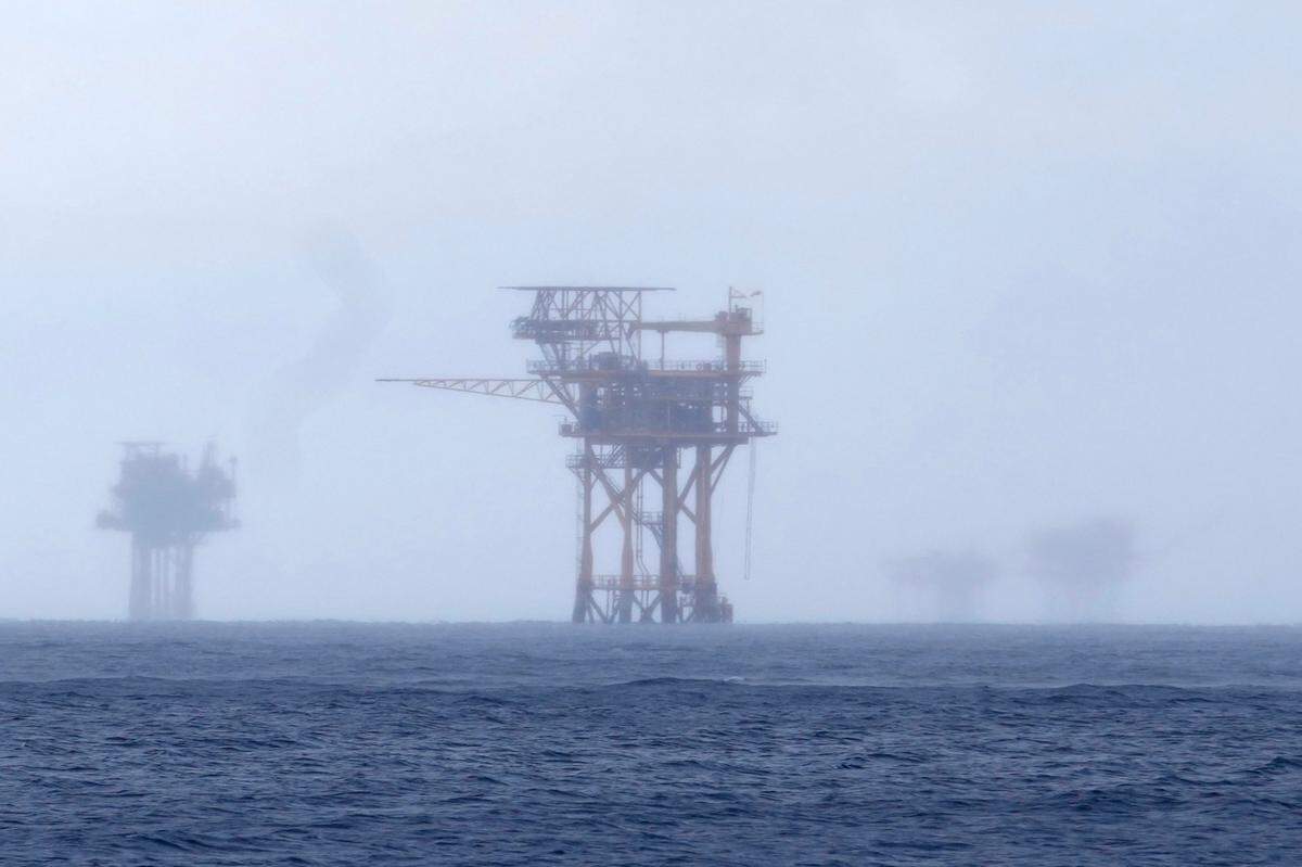 CORRECTS TO 382 MILLION NOT 328 FILE - Oil platforms are visible through the haze near the Flower Garden Banks National Marine Sanctuary in the Gulf of Mexico, off the coast of Galveston, Texas, Sept. 16, 2023. Oil companies offered $382 million for drilling leases in the Gulf Wednesday after courts rejected the Biden administration’s plans to scale back the sale to protect an endangered whale species. (AP Photo/LM Otero, file)