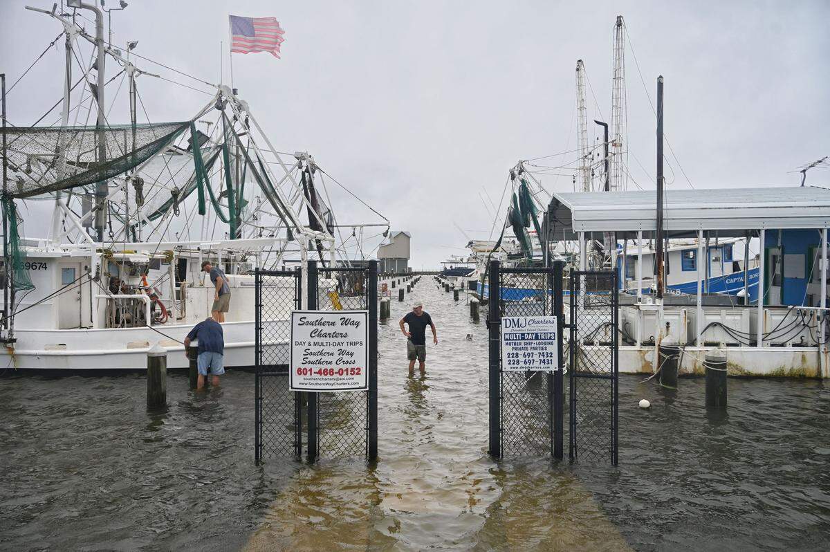 Owners tie down and secure their boats in the Pass Christian Harbor on Sunday, June 7, 2020, as storm surge from Tropical Storm Cristboal floods the harbor.