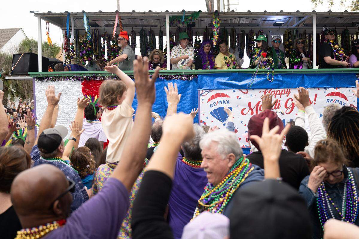 Members of the crowd cheer as floats pass down Lameuse Street.