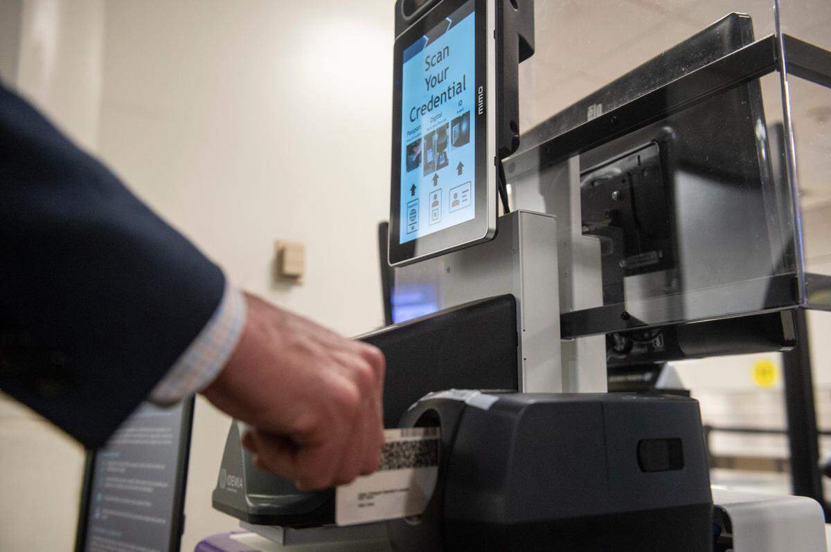 An airport employee demonstrates how to use the facial recognition software, called Credential Authentication Technology with Camera (CAT-2), at the TSA checkpoint at Gulfport-Biloxi International Airport in Gulfport on Wednesday, Dec. 7, 2022.