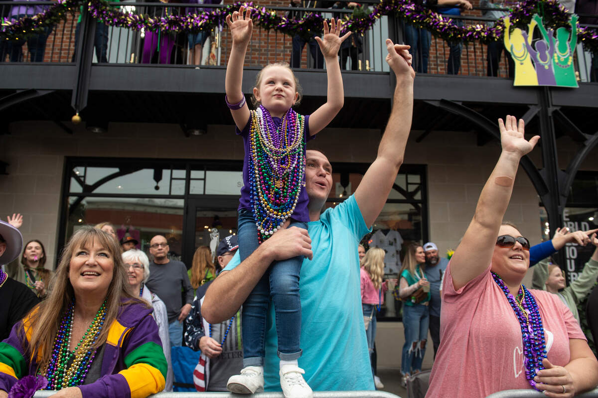 Parade attendees cheer for beads during The Ocean Springs Elks Carnival Parade in downtown Ocean Springs on Saturday, Jan. 27, 2024.