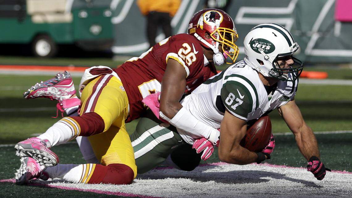 New York Jets wide receiver Eric Decker, right, scores on a touchdown pass from quarterback Ryan Fitzpatrick, not pictured, as Washington Redskins cornerback Bashaud Breeland makes the hit during the second half of an NFL football game, Sunday, Oct. 18, 2015, in East Rutherford, N.J. (AP Photo/Seth Wenig)