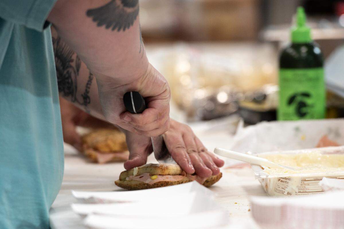 An employee prepares a sandwich at Tavi’s Salumeria in Gulfport.