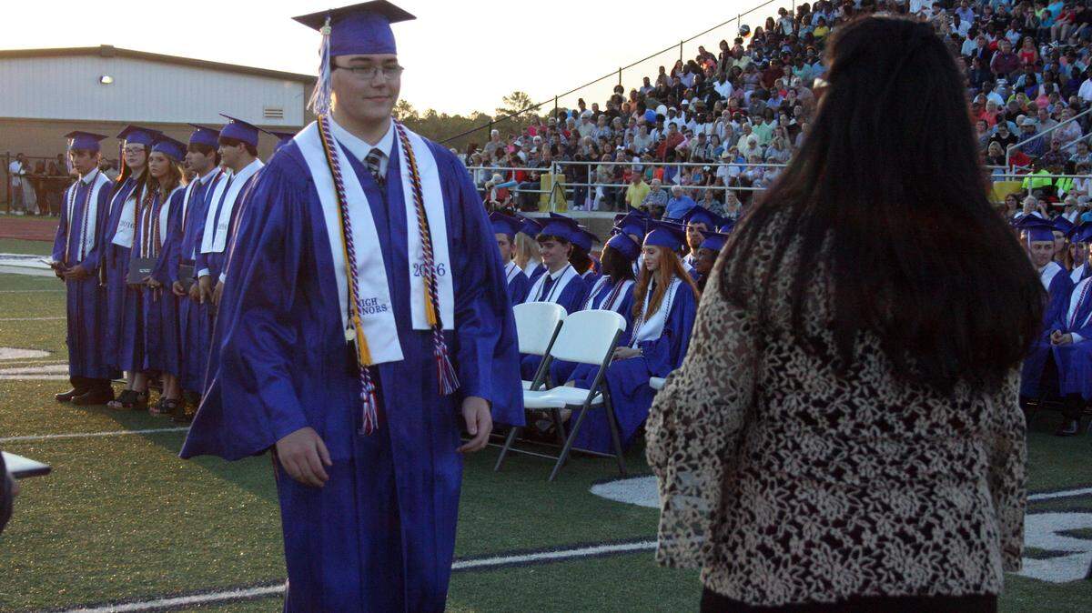 SHANNON DAVIDSON/sPECIAL TO THE SUN HERALD 
 Stone High School graduate Caleb Dean Avin greets Superintendent of Education Inita Owen and accepts his diploma during Stone High's commencement exercises Friday, May 20, 2016, at MGCCC's A.L. May Stadium in Perkinston.