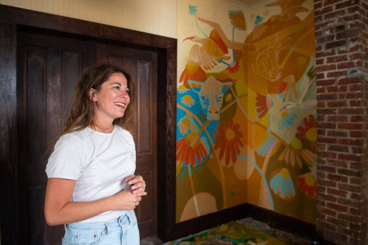 Julia Reyes stands in front of a mural she is working on at The Traveler, a new exhibit and restaurant at the Walter Anderson Museum of Art, in Ocean Springs.