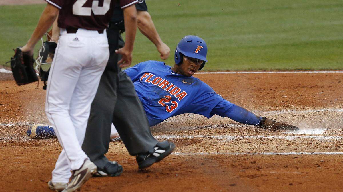 BRYNN ANDERSON/ASSOCIATED PRESS 
 Florida's Buddy Reed slides into home scoring against Mississippi State during the second inning of a Southeastern Conference NCAA college baseball tournament game Friday, May 27, 2016, in Hoover, Ala.